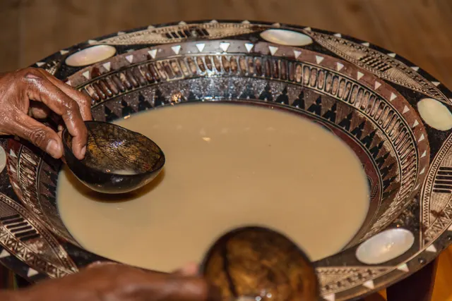 Yaqona (kava) mixed in a carved wooden tanoa bowl, served with a coconut-shell bilo
