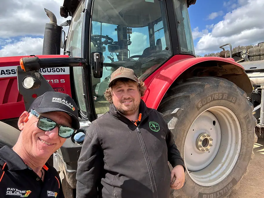 Integrantes del equipo REALM frente a un tractor