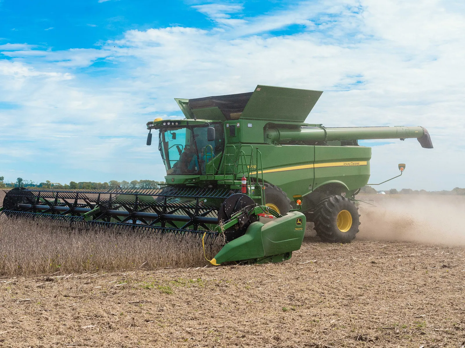 A combine harvester cutting a soybean crop